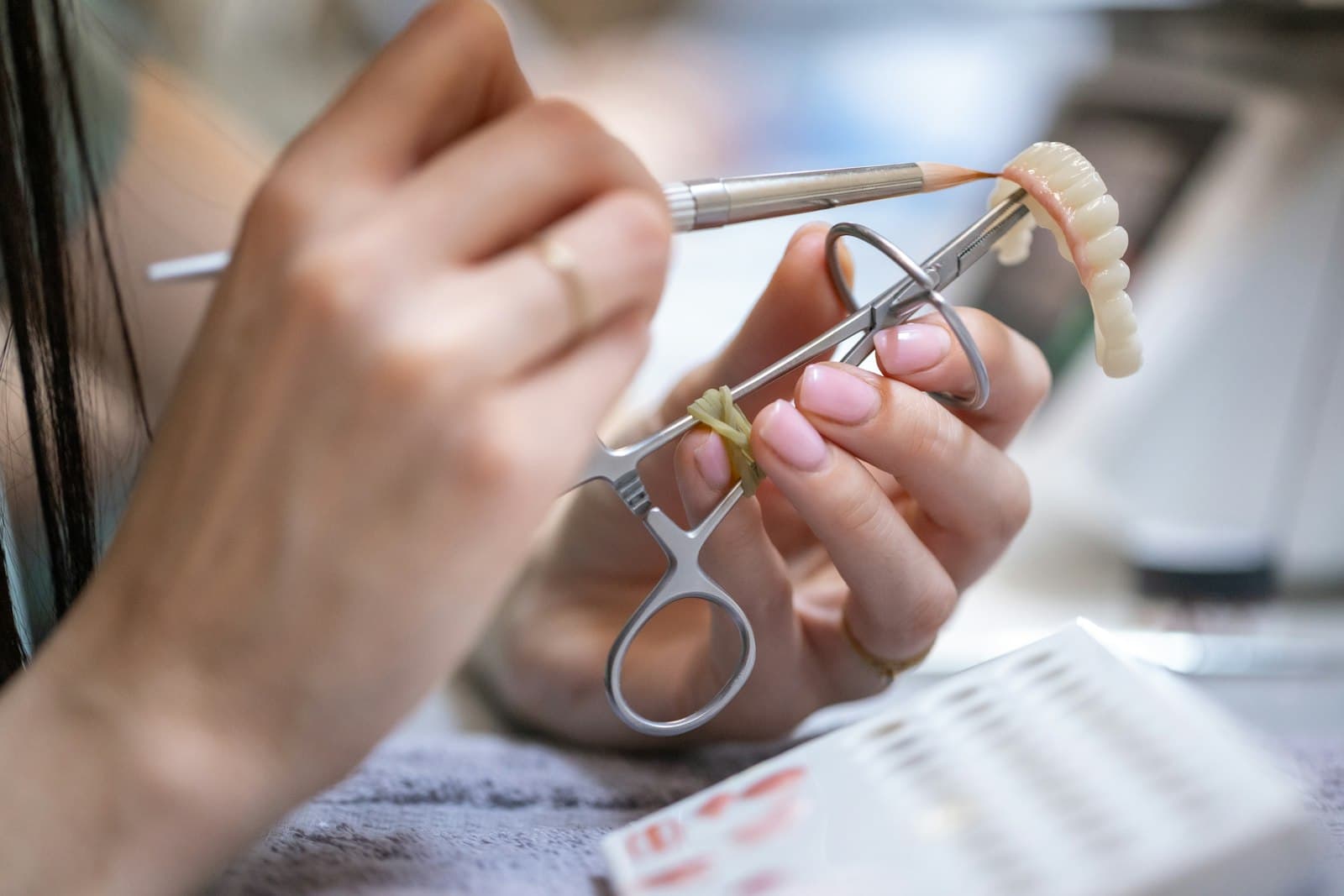 Dental lab technician shaping a crown.